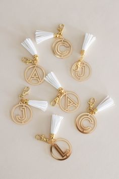 six charms with tassels and letters on them