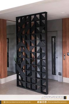 a room divider made out of black wood with geometric designs on the sides and doors