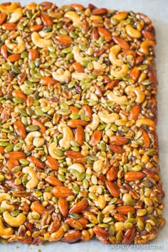 a square shaped food item with nuts and seeds on it