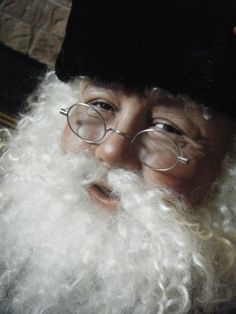 a close up of a person wearing glasses and a beard with long white curly hair