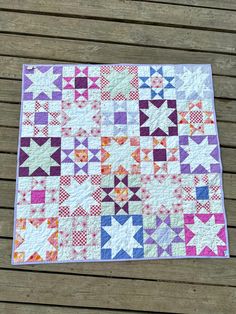 a quilted table topper on a wooden deck with wood planks in the background