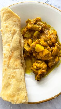 a white bowl filled with food next to a pita