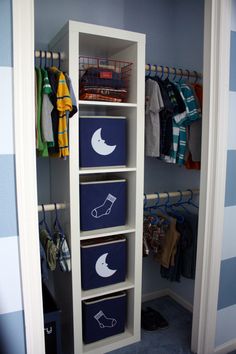 an organized closet with blue bins and white shelves