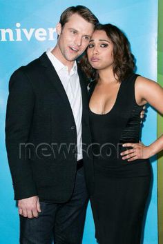 a man and woman standing next to each other in front of a blue wall with the words universal pictures on it