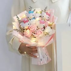 a person in a white coat holding a bouquet of pink roses and small stuffed animals