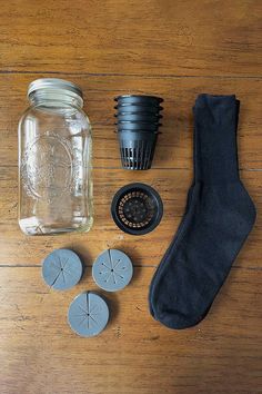 the contents of a mason jar are laid out on a wooden table next to some rubber cutters