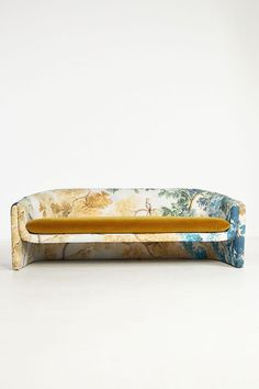 a couch that is sitting on top of a white surface with trees in the background