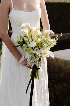 a woman in a white dress holding a bouquet