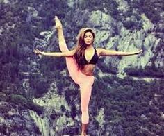 a woman standing on top of a rock with her arms outstretched