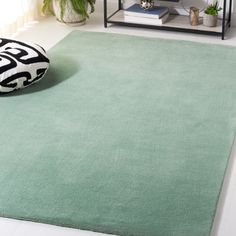 a living room with a green rug on the floor