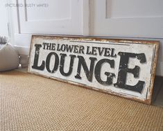 an old sign that says the lower level lounge is on the floor next to a door