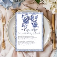 a plate with a blue bow on it next to flowers and silverware, along with a card that says will you be my something blue?