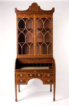 an old wooden desk with glass doors and drawers