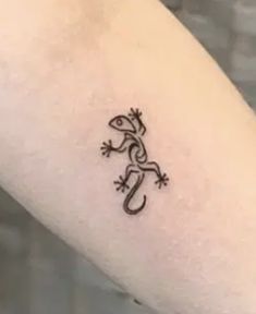 a small lizard tattoo on the arm