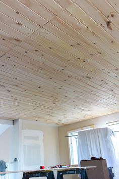 an unfinished ceiling with wood planks in a room that is being remodeled and painted