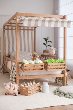 a child's bedroom with a canopy bed and toy animals on the floor next to it