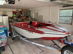 a red and white boat in a garage