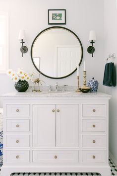 a bathroom vanity with a round mirror above it