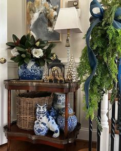 a table with blue and white vases sitting on top of it next to a lamp