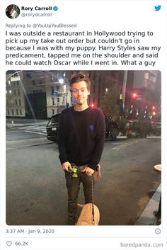 a man standing in the middle of a street next to a dog on a leash