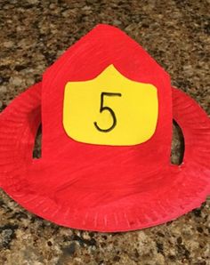 a red paper plate with a yellow number 5 on it sitting on top of a counter