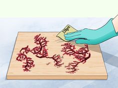 a person in blue gloves cleaning red corals on a cutting board