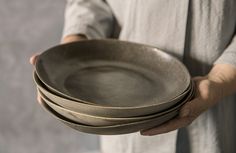 a person holding three bowls in their hands