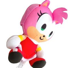 a pink stuffed animal with big eyes sitting on top of a white surface and wearing a red t - shirt