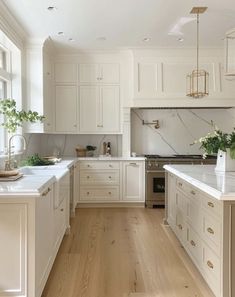 a large kitchen with white cabinets and wood flooring on the walls, along with an island in the middle