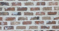 an old brick wall is painted brown and white