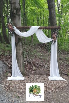 the wedding arch is decorated with flowers and white draping for an outdoor ceremony