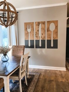 a dining room table and chairs with utensils hanging on the wall