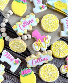 some decorated cookies are sitting on a wooden table with lemons and other items around them