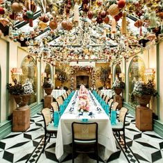 the dining room is decorated with christmas decorations and hanging balls above it, along with potted plants