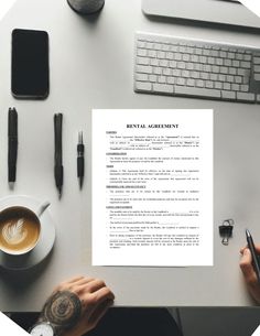 a person holding a pen over a paper on top of a desk