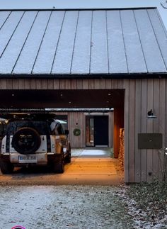 a jeep parked in front of a garage door with snow on the ground around it