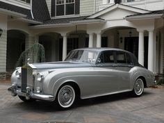 an old fashion car parked in front of a house