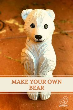 a white bear statue sitting on top of a wooden floor with the words make your own bear