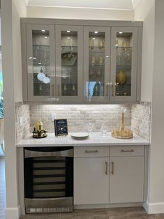 a kitchen with glass cabinets and white counter tops