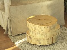 a wooden stool sitting on top of a rug next to a bed