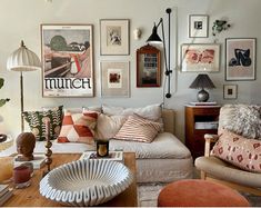 a living room filled with lots of furniture and pictures on the wall above it's coffee table