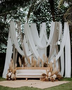 a white couch sitting in front of a lush green forest