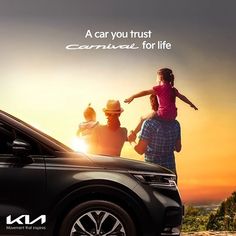 a family is sitting on top of a car with the sun setting in the background