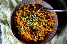 a bowl filled with food on top of a white table cloth next to a spoon