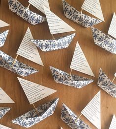 paper boats are arranged on a table with words written in the middle and small ones attached to them