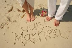 two people standing on the sand with their feet in the sand that says just married