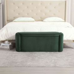 a bed with a green bench in front of it on the floor next to a nightstand