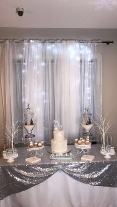 a table with silver sequins and white frosted cake on it's side