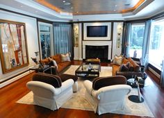 a living room filled with furniture and a flat screen tv mounted on the wall above a fire place