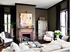 a living room filled with furniture and a fire place in front of a painting on the wall